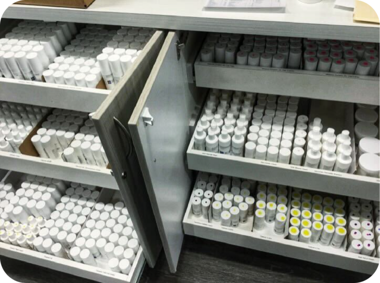 Drawers stocked with SKNV medications, featuring a variety of bottles and organized compartments for in-office dispensing.