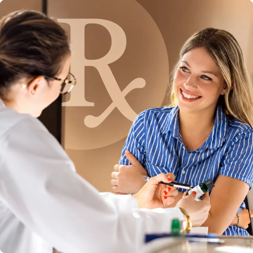 Dermatology provider in a white coat handing a smiling patient a green SKNV prescription bottle across a desk, in front of a large Rx symbol, illustrating in-office dispensing